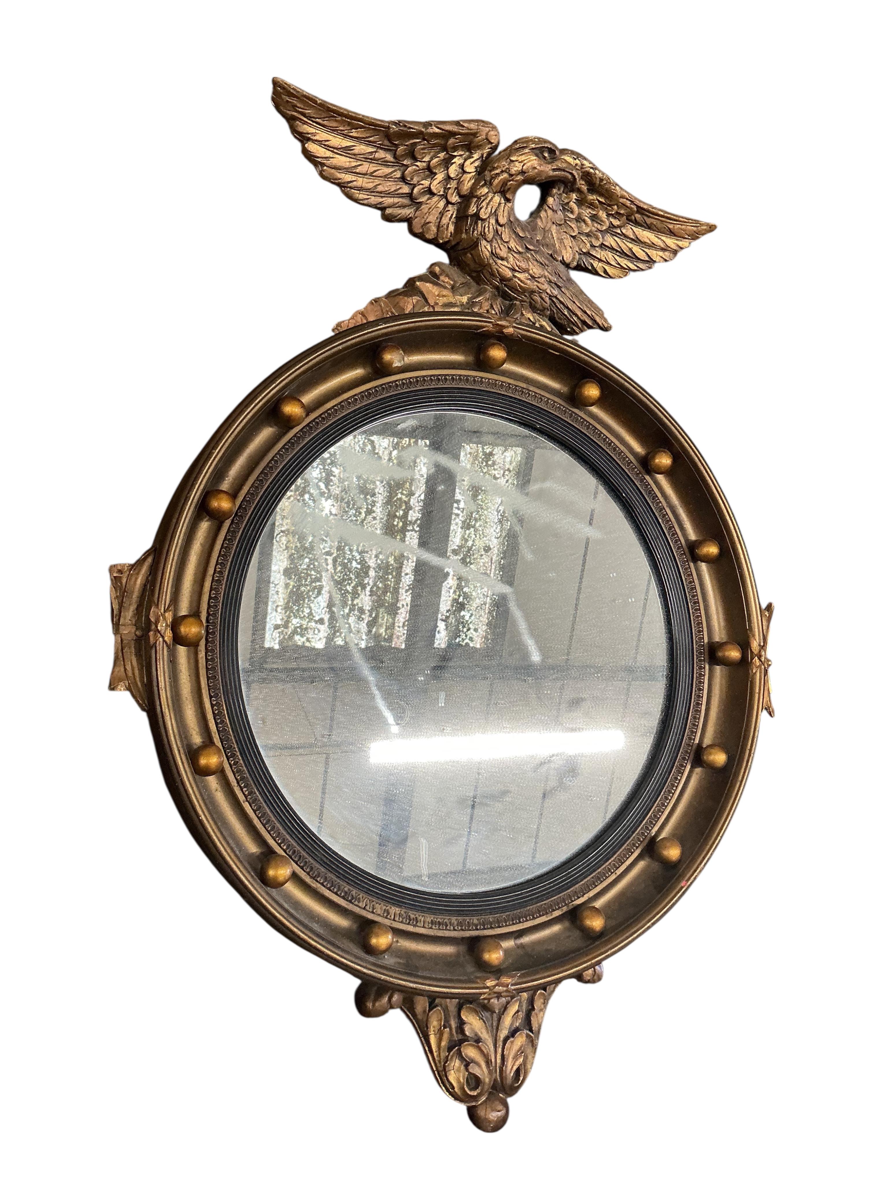 An early 20th century French giltwood and composition circular wall mirror, diameter 51cm, together with an Edwardian oval bevelled mirror and a Regency style wall mirror